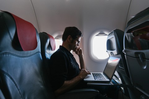 Empleado volando en el avión utilizando la aplicación Payhawk para calcular las emisiones de CO2 corporativas de la fase tres.